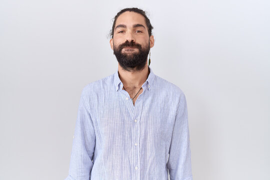 Hispanic man with beard wearing casual shirt puffing cheeks with funny face. mouth inflated with air, crazy expression.