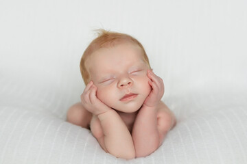 Sleeping newborn boy in the first days of life on white background.