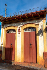 Beautiful colorful old mansions in the historic city of Sabará. Brazil. Blue sky. Stone-paved street. Vertical.