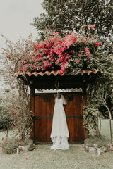 vestido de novia colgado en puerta rustica 