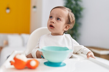 Adorable hispanic boy sitting on highchair at bedroom