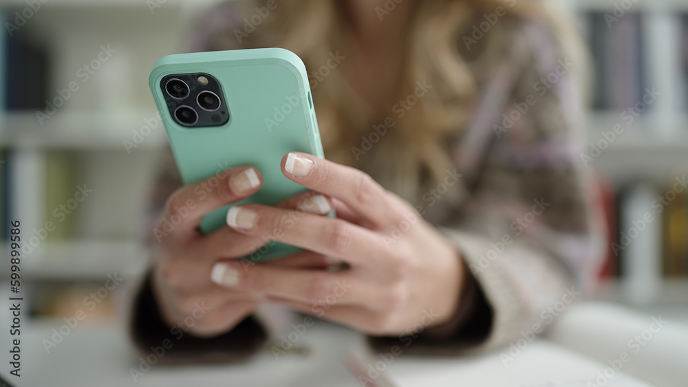 Poster Young blonde woman student using smartphone at library university