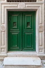 Fototapeta na wymiar old green door with decorations in the door frame