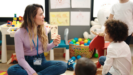 Woman and boy having vocabulary lesson with word cards at kindergarten