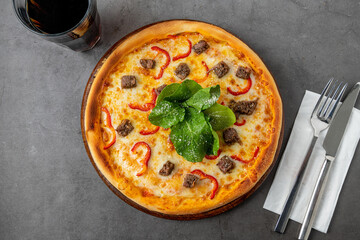 Pizza with paprika and roast beef on cutting board on stone table