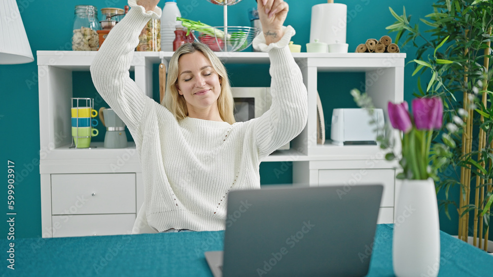 Poster Young blonde woman using laptop dancing at dinning room