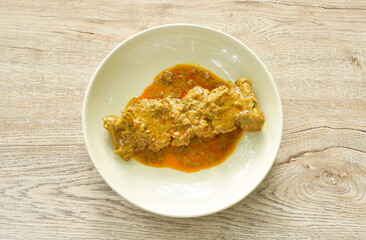spicy fried pork bone with curry and basil leaf on plate