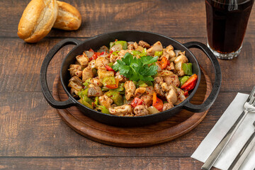 Sauteed chicken with pepper in a cast iron pan