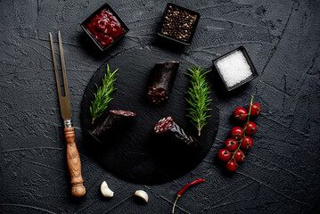 Spanish black pudding or blood sausage with rosemary on a stone background