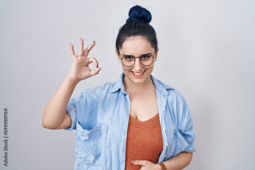 Canvas Prints Young modern girl with blue hair standing over white background smiling positive doing ok sign with hand and fingers. successful expression.