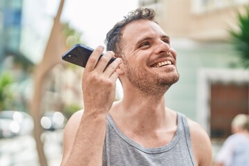 Young hispanic man smiling confident listening audio message by the smartphone at street