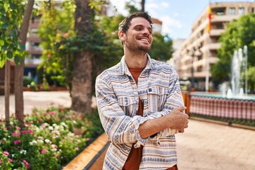 Fototapeta premium Young hispanic man smiling confident standing with arms crossed gesture at park