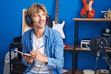 Young man artist composing song at music studio