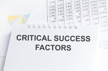 Notepad with inscriptions CRITICAL SUCCESS FACTORS on a white office background.