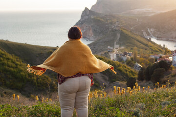 young woman sitting on the edge of the cliff
