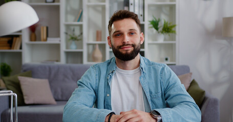 Smiling young adult man looking camera during webinar, online class, virtual meeting. Caucasian...