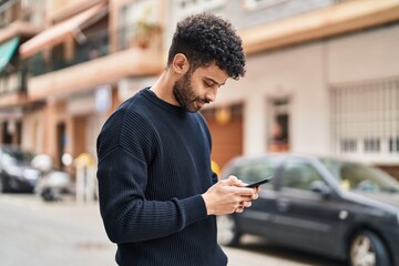 Young arab man using smartphone at street