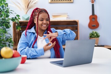 African american woman using laptop communicate with deaf language at home