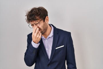 Hispanic business man wearing glasses tired rubbing nose and eyes feeling fatigue and headache. stress and frustration concept.