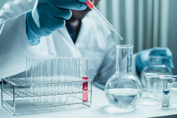 Scientist holding flask with lab glassware and chemistry laboratory test tubes Research and development in science laboratory, science technology concept
