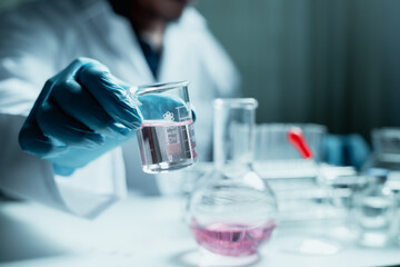 Scientist holding flask with lab glassware and chemistry laboratory test tubes Research and development in science laboratory, science technology concept
