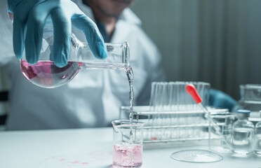 Scientist holding flask with lab glassware and chemistry laboratory test tubes Research and...
