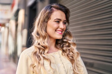 Young woman smiling confident looking to the side at street