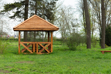 Obraz premium Wooden gazebo for relaxing in the park at spring