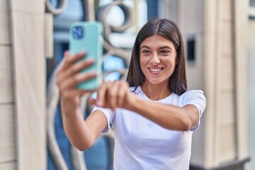 Young beautiful hispanic woman smiling confident making selfie by the smartphone at street