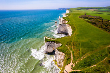 Aerial  view of limestone cliffs and stacks with countryside at Old Harry Rocks in Dorset, UK. - obrazy, fototapety, plakaty