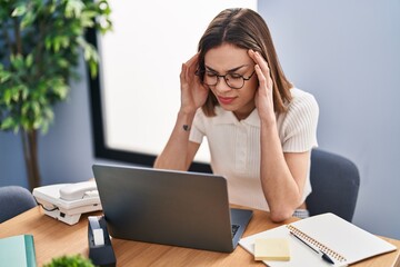 Young beautiful hispanic woman business worker stressed using laptop at office