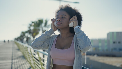 African american woman listening to music with relaxed expression at street © Krakenimages.com