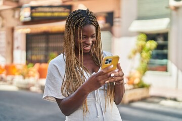 African american woman smiling confident using smartphone at street