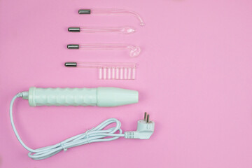 Darsonval for body and hair care on a pink background. Therapy for skin. Darsonvalization. Top view. Copy space.