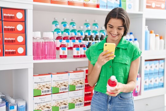 Young hispanic woman customer make photo to medicine bottle at pharmacy