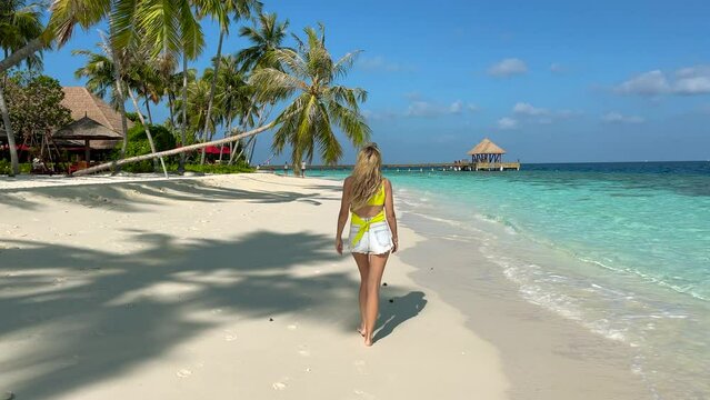 Lonely girl walks along the tropical coast of Mauritius