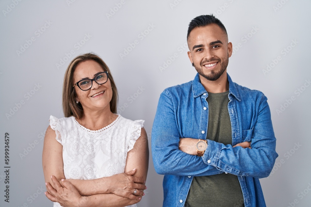 Sticker Hispanic mother and son standing together happy face smiling with crossed arms looking at the camera. positive person.