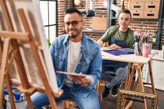 Two men artists smiling confident drawing at art studio