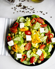 A green vegan salad made from a mix of green leaves and vegetables. white background