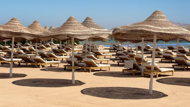 Straw umbrellas and sunbeds at Rimini beach in Italy