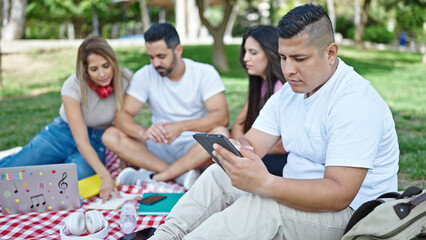Group of people students using touchpad studying at park