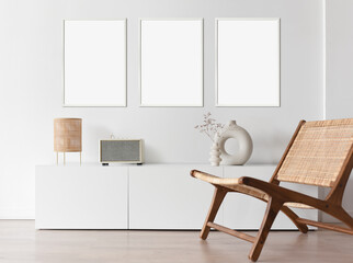 Blank picture frame mockup on white wall. Modern living room design. View of modern scandinavian style interior with sofa. Three vertical templates for artwork, painting, photo or poster