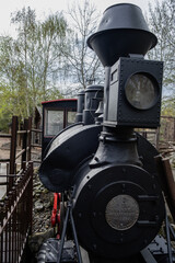 A powerful locomotive chugs through a lush, green plant surrounded by trees. Its metal steam engine powering the train forward in its transportation journey.