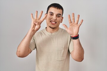 Young arab man wearing casual t shirt showing and pointing up with fingers number nine while...