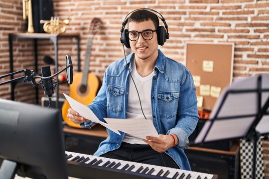 Young Man Musician Holding Music Sheet At Music Studio