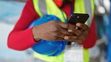 African american woman architect using smartphone at street