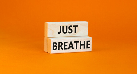 Just breathe and psychological symbol. Concept words Just breathe on beautiful wooden block. Beautiful orange table orange background. Business psychological and Just breathe concept. Copy space