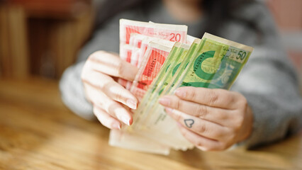 Hands of woman counting shekels banknotes at room