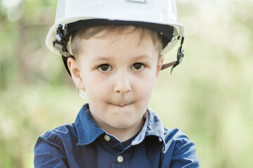 portrait of a small boy with a construction helmet

