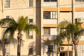 Typical old aged Architecture in Israel street. 60s buildings with fascade wall .windows after Palm trees